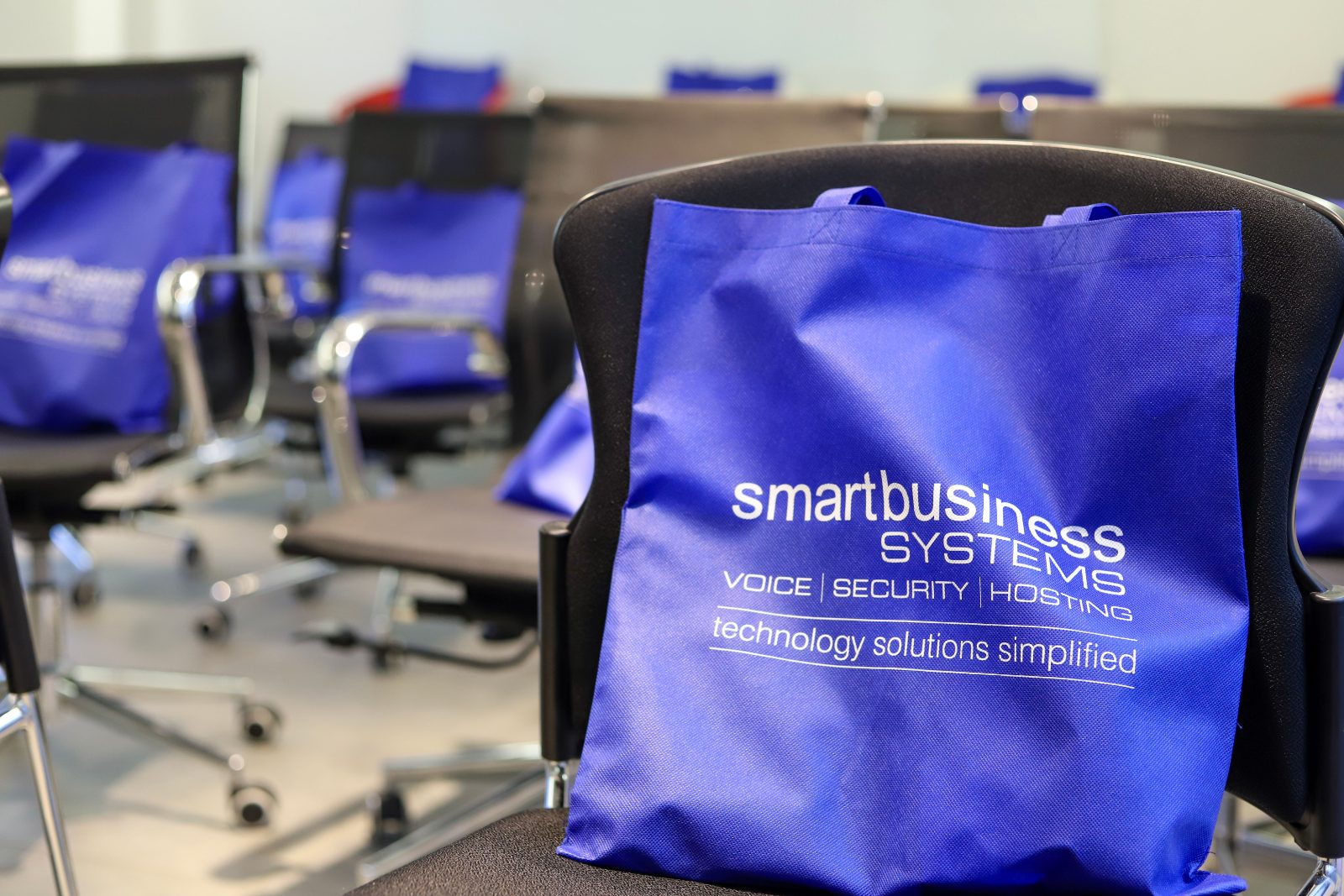 Smart Business Systems branded tote bags on chairs at a client event
